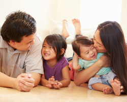Portrait Of Family Lying On Floor At Home Portrait Of Family Lying On Floor At Home